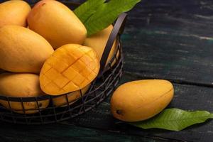 Cut and intact mangoes in the dark background photo