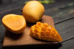 Cut and complete mangoes on the chopping board photo