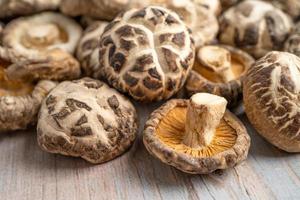 Dried shiitake mushroom on wooden background. Healthy food photo