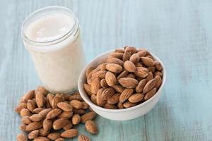 cuenco de almendras con vaso de leche de almendras foto