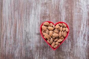 almendras en tazón rojo en forma de corazón foto