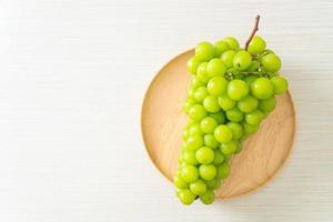 Fresh green grape on wood plate photo