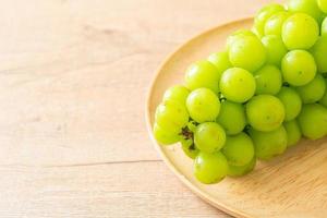 Fresh green grape on wood plate photo