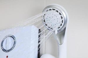 baño, calentador de agua en la ducha foto