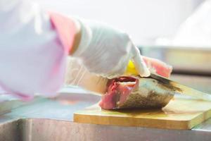 Chef cutting fresh tuna fish in the kitchen
