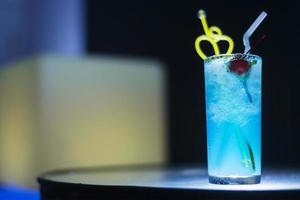 blue curacao cocktail drink with cherry at night photo