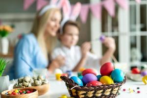 Closeup, colored eggs, on blurred background of mother and her cute son.
