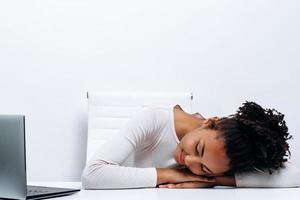 Closeup portrait of young beautiful woman sleeping near laptop computer on table. Overwork concept. photo