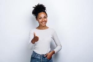 Charming stylish young girl, girl reaches out to say Hello, on a white background photo