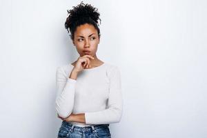 Pensive girl on a white background looks away on a white background photo