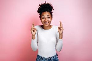 Portrait young woman in casual clothes with dark hair, crossing her fingers, feeling nervous before an important event photo