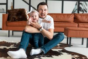 A father and child are sitting and the ground is posing beautifully for the camera photo