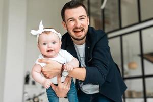 Cheerful father with his tiny daughter have fun. Pampers your child photo