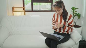 junge Frau auf der Couch bei einem Videoanruf mit einem Laptop video