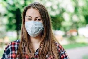 Linda chica en una máscara protectora sobre un fondo de naturaleza foto