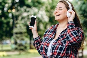 Beautiful, attractive brunette enjoys a favorite song that comes from headphones. photo