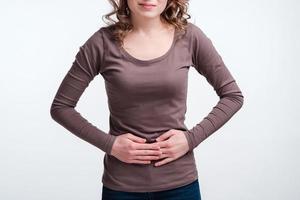 Young girl with abdominal pain close up, stomach pain clutching her stomach photo