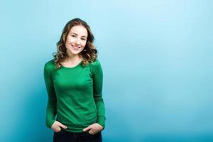 niña sonriente posando en suéter verde. foto