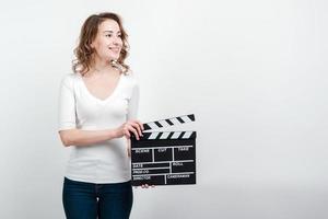Attractive woman holding a clapboard isolated over white background photo