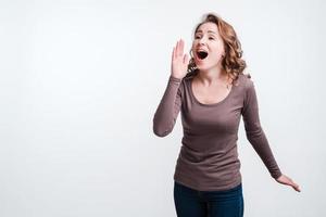 Portrait of an excited woman  screaming over white background. Call someone photo