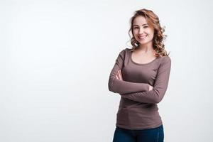 Happy  pretty woman standing with folded hands wearing casual clothes over white background photo