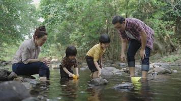 Cámara lenta de familia asiática divirtiéndose junto al río. video