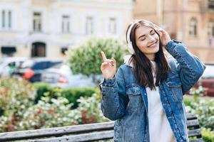 hermosa y atractiva morena disfruta de una canción favorita que sale de los auriculares. foto