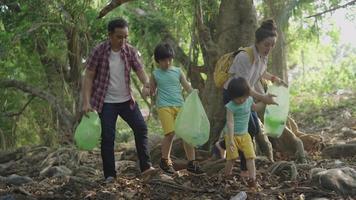 família asiática coletando lixo na natureza