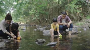 familia asiática divirtiéndose junto al río