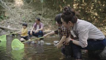 Asian parents teaching their two kids how to fish video