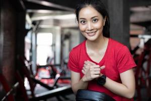 hermosa mujer en forma muscular ejercicio de construcción de músculos y fitness mujer haciendo ejercicios en el gimnasio. fitness - concepto de estilo de vida saludable foto