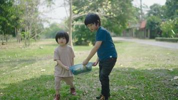 dos niños sacan trozos de frutas y verduras para aprender a hacer abono natural video