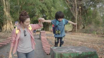 Aziatische moeder speelt met haar kind in de natuur video