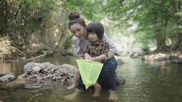 Asiatische Mutter bringt ihrem Kind bei, wie man am Fluss fischt video