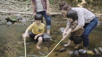 padres asiáticos enseñando a sus dos hijos a pescar video