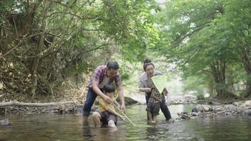 Asian parents teaching their two kids how to fish video