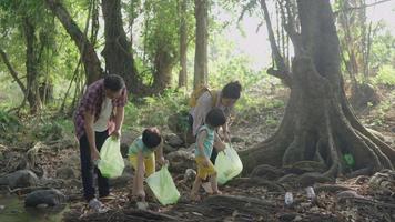 asiatische Familie, die Müll in der Natur sammelt