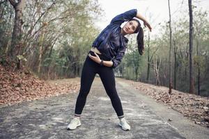 Athletic woman asia warming up and Young female athlete exercising and stretching in a park before Runner outdoors, healthy lifestyle concept. photo