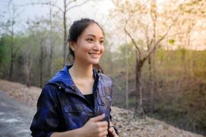 Asian women smiling and happy while jogging outside on the street in the park. photo