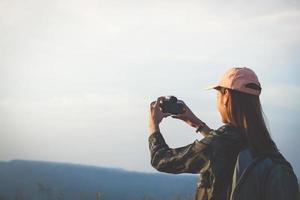 Asian  young women people Hiking with friends backpacks walking together and looking map and taking photo camera by the road and looking happy ,Relax time on holiday concept travel