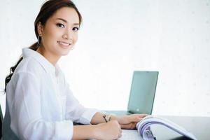 Asian business women using notebook and  smiling happy for working photo