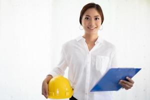 Asian women engineering inspecting and working and holding blueprints at office photo