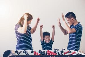 Happy Family playing table football for relax on holiday in home photo