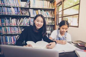 estudiantes asiáticos leyendo libros en la biblioteca.