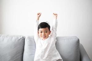 Familia e hijo emocionados y felices con los brazos levantados mientras ve la televisión en casa foto