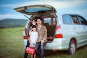 Niña feliz con familia asiática sentada en el coche para disfrutar de un viaje por carretera y las vacaciones de verano en autocaravana foto