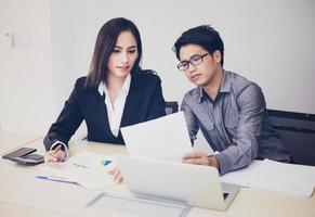 Asian businessmen and group using notebook for business partners discussing documents and ideas at meeting and business women smiling happy for working photo