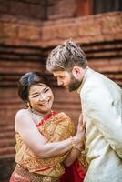 Asian bride and Caucasian groom have romantic time with Thailand dress photo