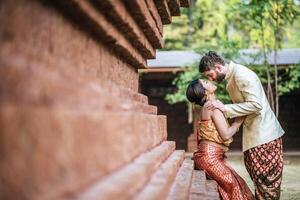 Asian bride and Caucasian groom have romantic time with Thailand dress photo