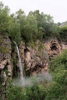 Beautiful mountain waterfall on rainy day photo